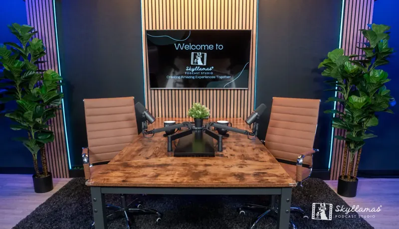 The Skyllamas Podcast Studio desk set with four microphones, chairs and a welcome screen