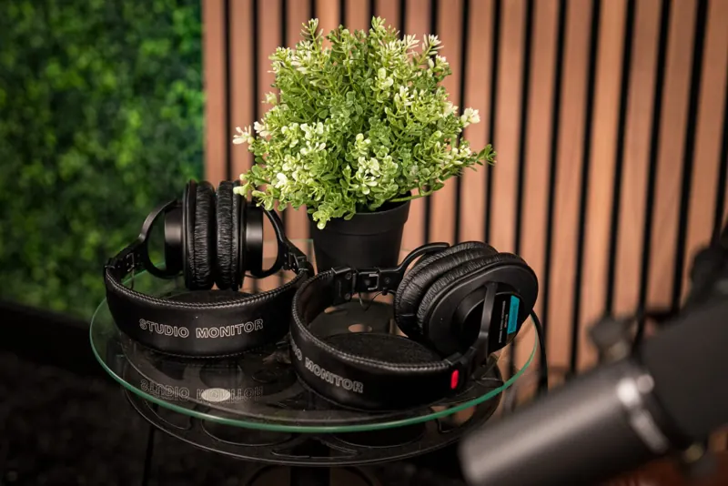 Studio headphones on a side table between the armchairs